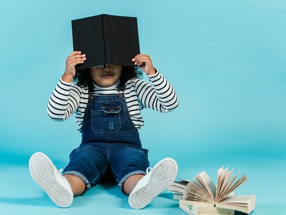 Bambina con libro in mano. Le favole della nonna: un momento speciale per Amelia e sua mamma