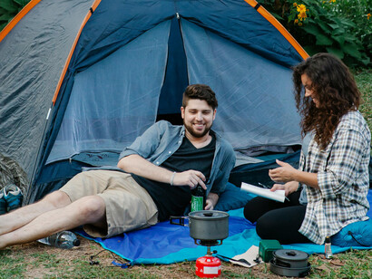 A couple relaxing outside their tent on camping trip