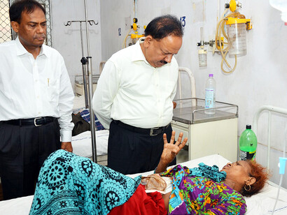 Dr. Harsh Vardhan, Union Minister for Health and Family Welfare, interacts with a patient during his visit to Safdarjung Hospital to review sanitation efforts in New Delhi hospitals on June 13, 2014