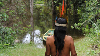 Mulher indígena de origem Guarani caminha no interior de uma mata na fronteira entre Brasil e Paraguay