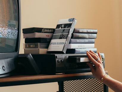 A hand adjusting VCR, symbolizing the personal rituals behind the nostalgia loop