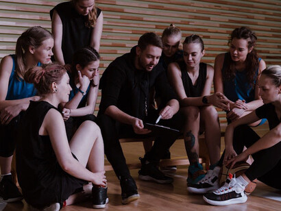 Focused and engaged, the players listen intently to their coach, demonstrating how effective sports management combines motivational encouragement with clear tactical instructions