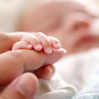 Niña recién nacida tomando los dedos de su madre: a partir de ahora mi deber era cuidarla, enseñarle el camino al colegio, cómo cruzar las calles, pasear al perro, la mejor forma de celebrar los cumpleaños y comer frituras