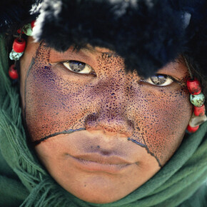 Kazuyoshi Nomachi, Tibet, Una ragazza nomade con il volto cosparso di una sostanza protettiva durante un pellegrinaggio, Tibet, Cina 1990 © Kazuyoshi Nomachi
