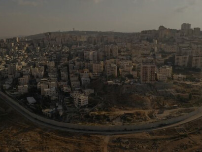An overhead view vividly depicts the division between Israel and Palestine, marked by the imposing security wall