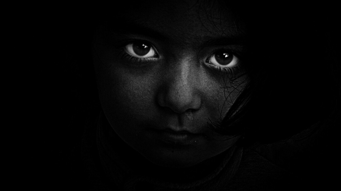 The bright eyes of a child enlighten the darkness of modern society in hope for a better future