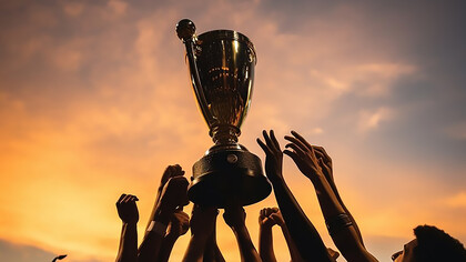 Celebrate victory with a compelling image of hands lifting a football cup, symbolizing triumph and success in soccer championships