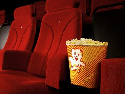 Un paquete de palomitas en la butaca de una sala de cine
