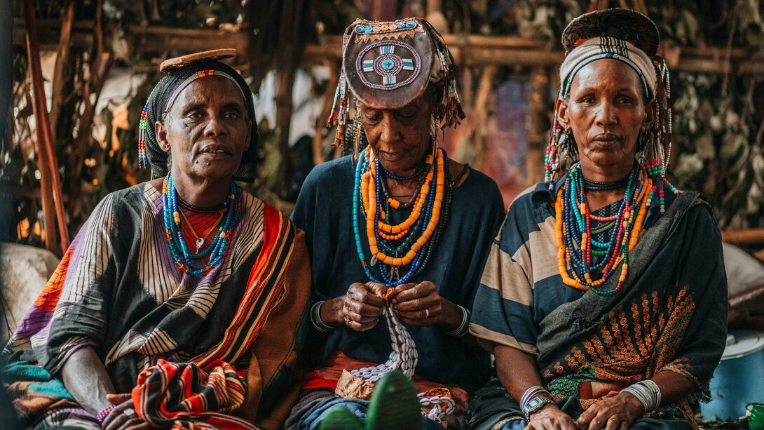 Three women in traditional dress, capturing the intersection of identity, labour, and resilience