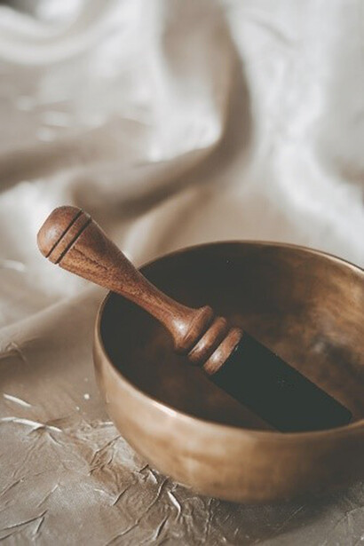 A brown wooden spoon rests on top of a round brown bowl