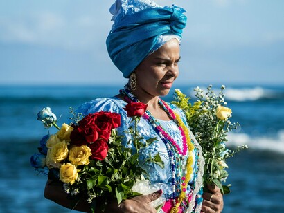 Mulher entrega oferendas à entidade. O folclore, a cultura popular e as culturas populares são permeadas pelo simbólico. A forma de estar no mundo, como vivemos (ou melhor, como sobrevivemos), atiça e aguça o nosso imaginário. Mas, podemos legitimar o imaginário? Sim, podemos a partir da cultura