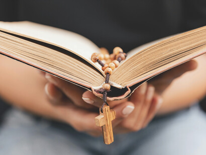 Una biblia abierta con rosario encima