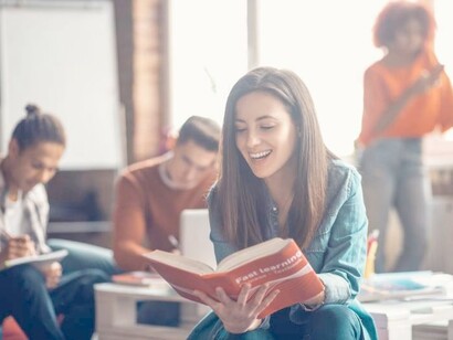 A young woman learning languages by reading out loud in a classroom
