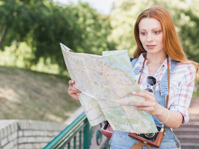 A young woman exploring a park with a map in hand, embracing the journey of love migration and adapting to a new culture in a foreign country