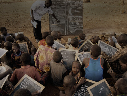 UNESCO instructor teaching a group of Karimojong youths in northeastern Uganda. The Karimojong are a seminomadic pastoral herding society. © UNESCO/Marc Hofer