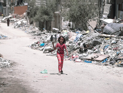 Una niña camina por las calles de la destruida Gaza en busca de comida. La población gazatí sufre un asedio prolongado que les impide el acceso a alimentos, medicinas y servicios básicos, provocando una catástrofe humanitaria deliberadamente provocada