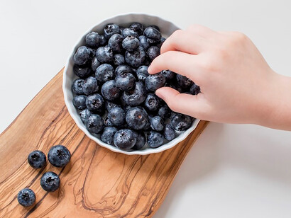 Blackberries arranged on a rustic brown wooden chopping board