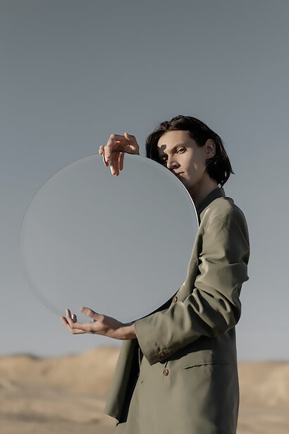 A gentleman, clad in a sophisticated suit, elegantly holds a pristine, round hand fan