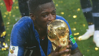 Le footballeur français Ousmane Dembélé, lauréat du Ballon d'or 2025, brandissant le trophée de la Coupe du monde de la FIFA après la finale du tournoi, le 15 juillet 2018