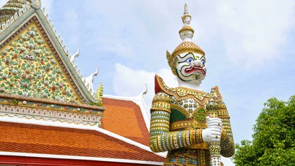 Yaksha and Yakshini sculptures at an Indian temple; giant guardian statue at a Thai Buddhist temple