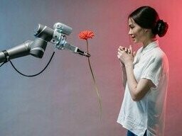 Robô oferece uma flor. A introdução de obras de IA no mercado de arte movimenta cifras expressivas e redefine as fronteiras da valorização da arte. A arte criada por IA vem ocupando um espaço crescente, atraindo colecionadores e investidores curiosos sobre o futuro do mercado e as novas estéticas



