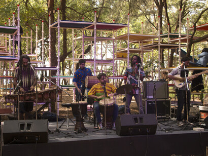 Boombay Djembe Folas performing at the Art Park, with the Charpai installation in the backdrop