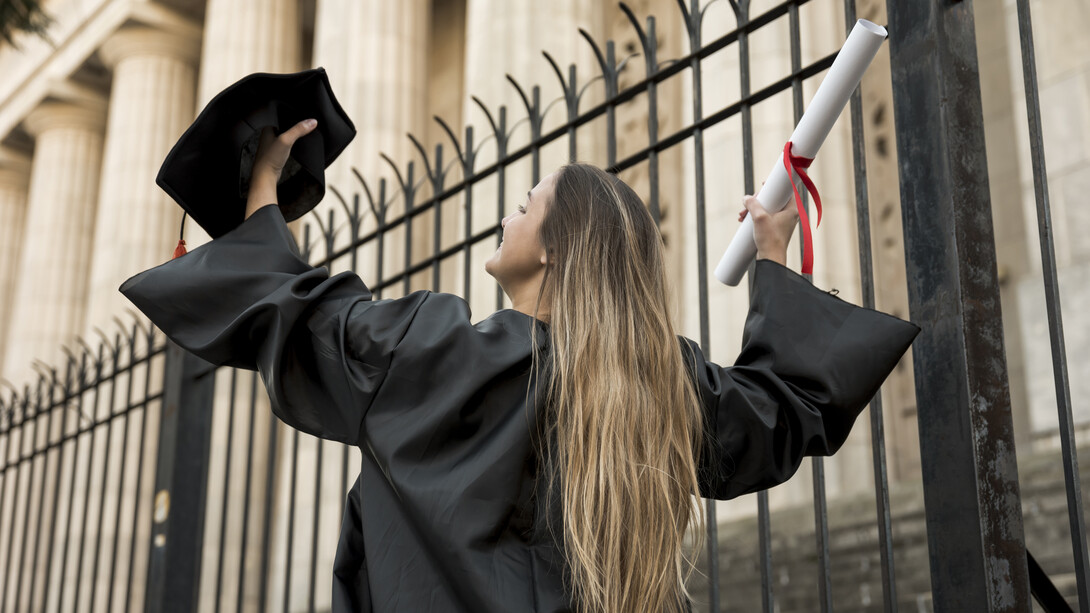 A young woman celebrating after graduating