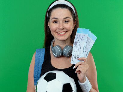 Smiling fan with tickets and gear reflect connection between fan and merchandise revenue