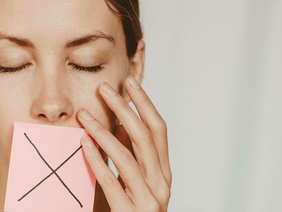 A woman covers her mouth against communication
