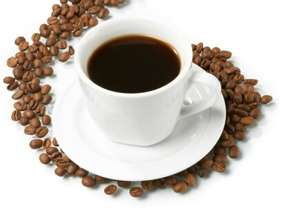 Una taza de café rodeada de granos