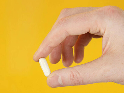 Mano con pillola bianca medicinale