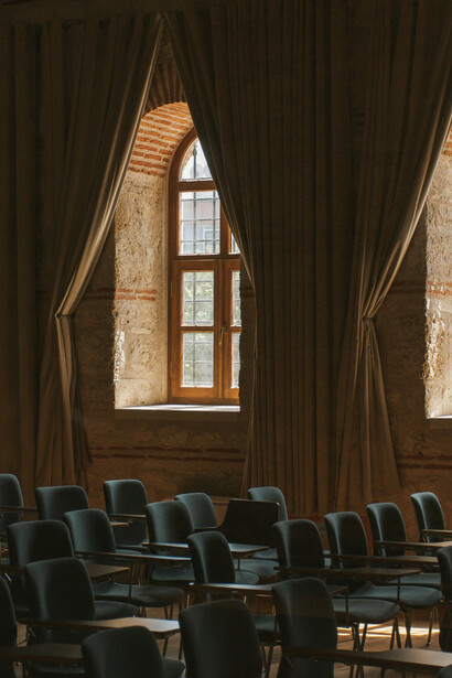 Empty chairs in a quiet university lecture hall — a silent reflection of the spaces once filled with debate and discovery