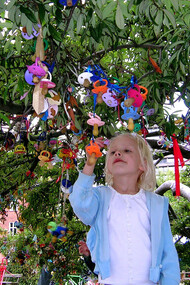 Una niña cuelga su chupete en el árbol
