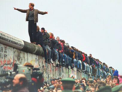 People sitting on top of the Berlin Wall on the day it fell on November 9, 1989, Berlin, Germany