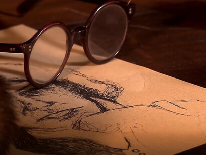 Boa di struzzo, occhiali e immagine di Grazia Deledda