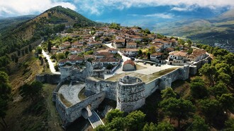 The fortified walls of Berat Castle surrounding a historic hillside neighborhood, highlighting the architectural heritage of Berat, Albania