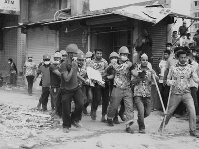 The scene of destruction and the numerous people gathered highlight the human cost of the exploitation of labor and poor working conditions associated with conventional fashion