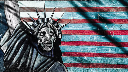 A wall painting of the American flag and a skull-shaped Statue of Liberty explores powerful themes of identity, decay, and national symbolism