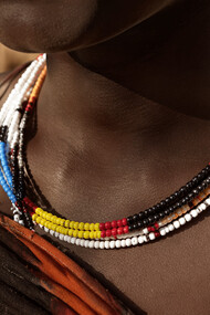 A close-up of beadwork worn by a woman, representing cultural identity and personal history