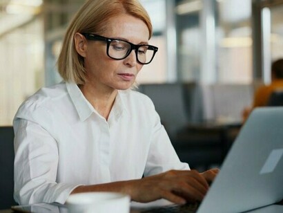 A professional reviewing information on a laptop, reflecting the need for vigilance when handling confidential business communications