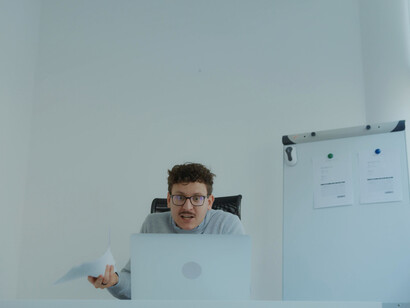 Behind the laptop, a sense of exhaustion and discontent is palpable, reminding us of the importance of fostering supportive work environments