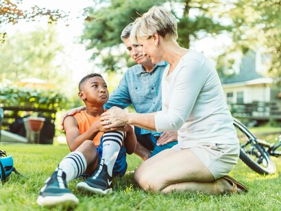 A young athlete receiving reassurance from caring parents, symbolising the stability parents provide during emotional moments