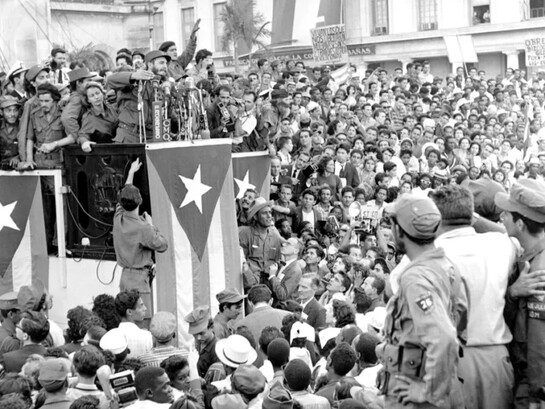Fidel Castro discursa diante de uma multidão em frente ao palácio presidencial em Havana, Cuba, comemorando a vitória da Revolução Cubana, em 1959. O artigo revisita criticamente o comunismo, as esquerdas e as epistemologias do Sul, distinguindo os conceitos filosóficos e políticos das diferentes experiências históricas que marcaram os séculos XX e XXI. A fotografia evoca um dos processos revolucionários mais influentes do século XX, tema que o artigo aborda ao refletir sobre comunismo, esquerda e projetos de transformação social