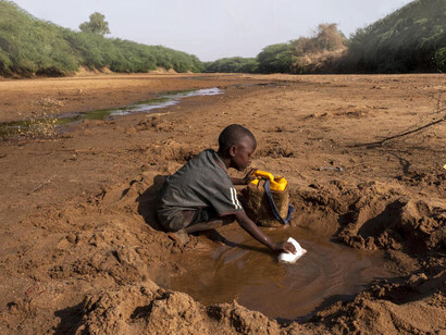 Niño recolectando agua en África