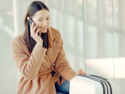 Mulher encantadora falando em smartphone no aeroporto