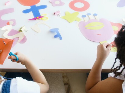 Two children cutting paper together and learning empathy