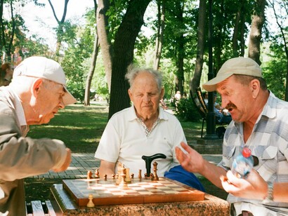 Gruppo di amici al parco che giocano a scacchi. Vivere la vecchiaia in compagnia, ma in libertà
