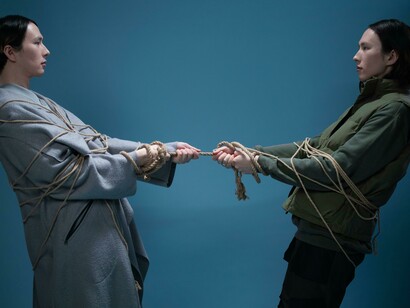 Due persone legate insieme da una corda: "Ci si dimentica allora che l’umanità è una sola, che l’essere umano è uguale in tutti i corpi in cui si declina, l’umanità è come un grande essere vivente, che ingloba tutti, andando al di là delle differenze e delle specificità di ognuno"