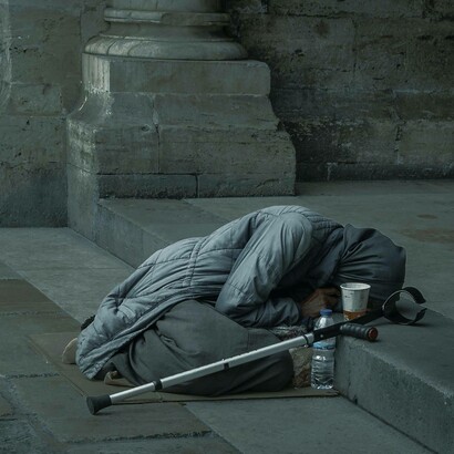 Mendicante rannicchiata sulle scale di un monumento: "... le classi medie si sono impoverite enormemente senza che ne risulti alcun beneficio per le finanze dello Stato"