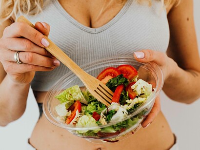 A woman in her sporting wear eating a salad